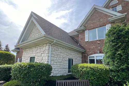 Angled front view of brick and stone house.